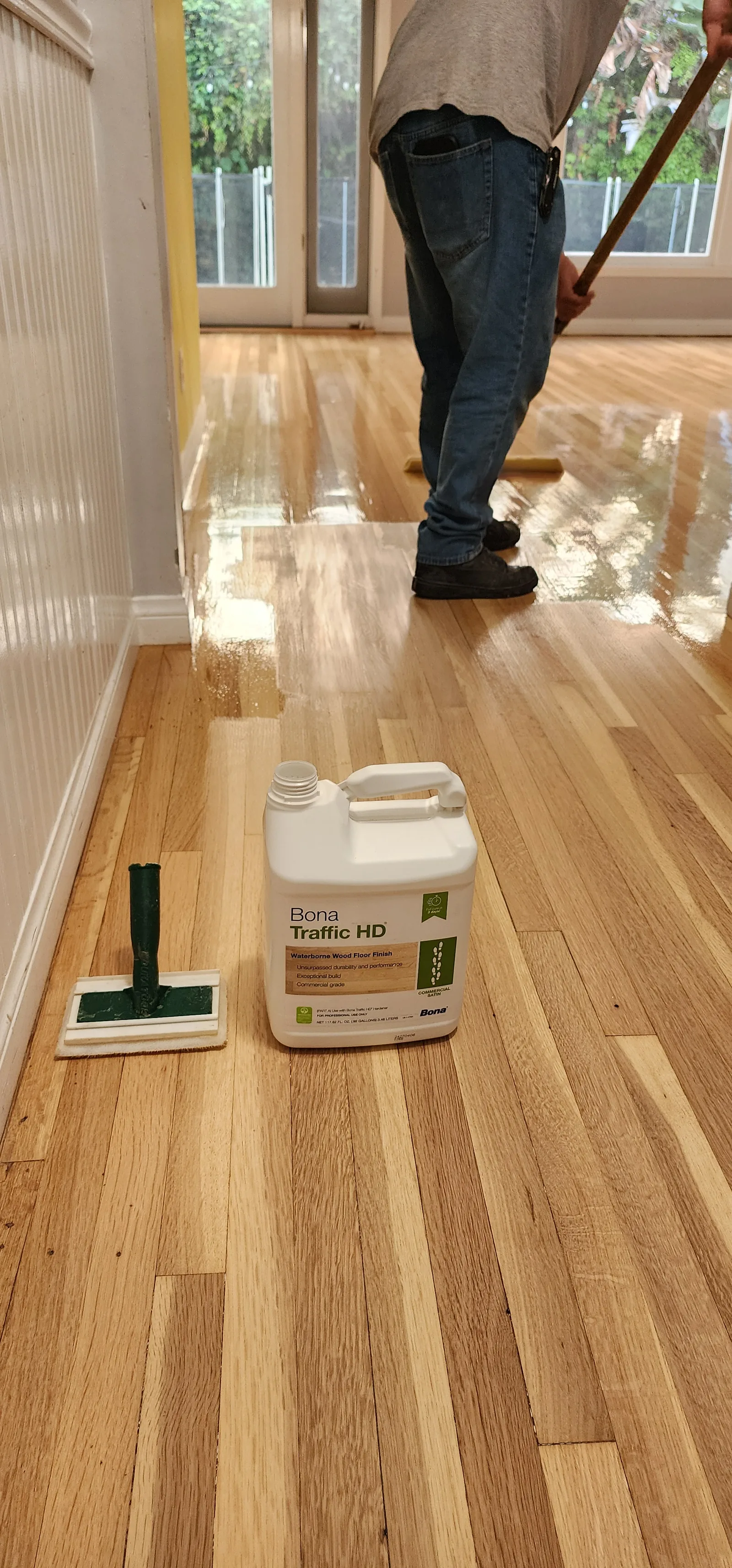 Applying a protective finish coat to a freshly sanded oak floor