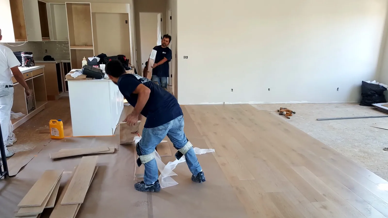 Crew laying planks next to a kitchen island