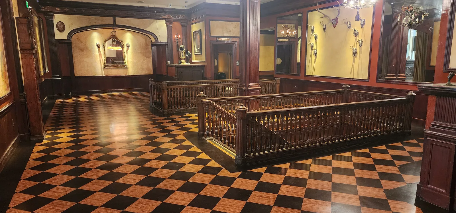 Historic venue with checkerboard wood parquet and ornate timber railings