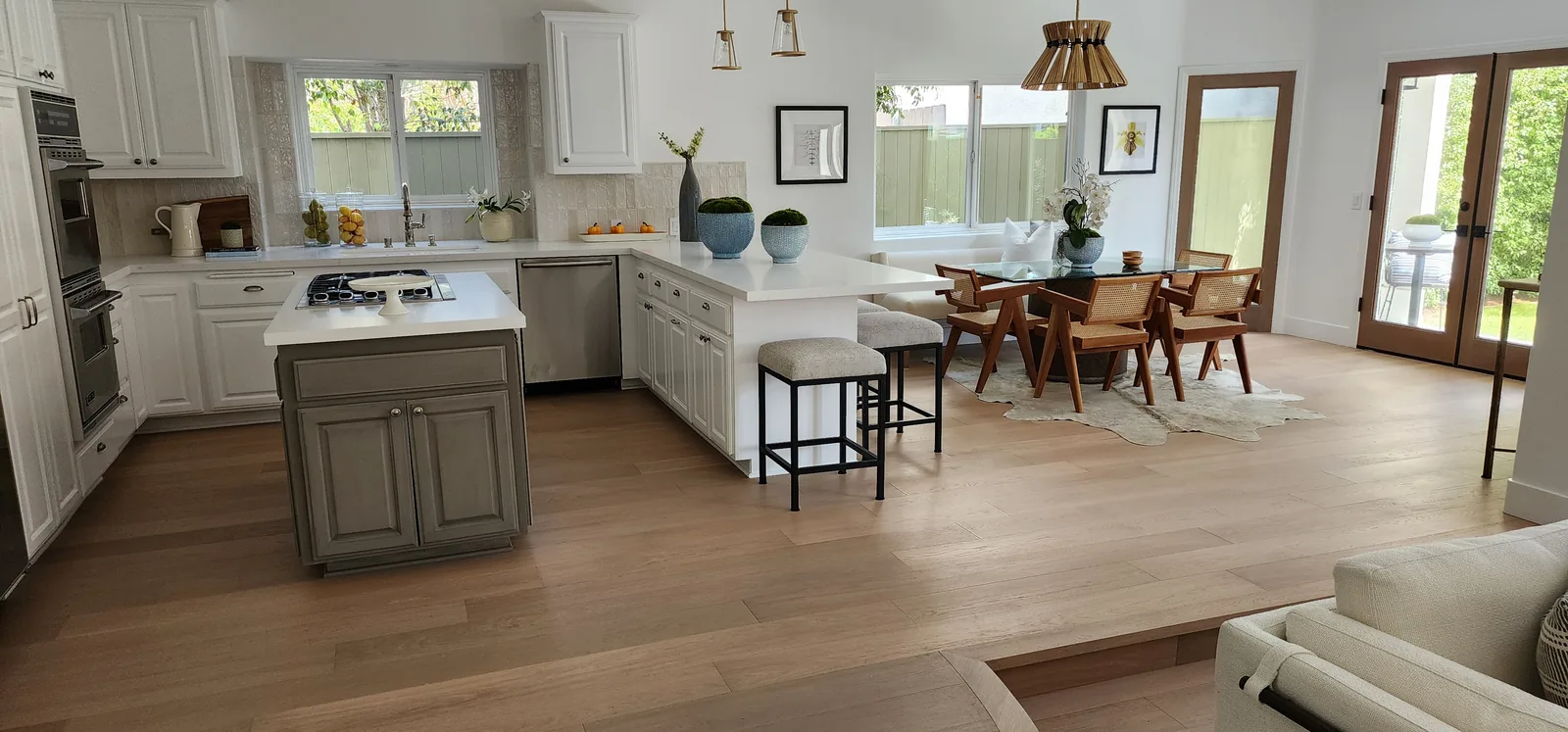 Kitchen island and dining area over light oak flooring
