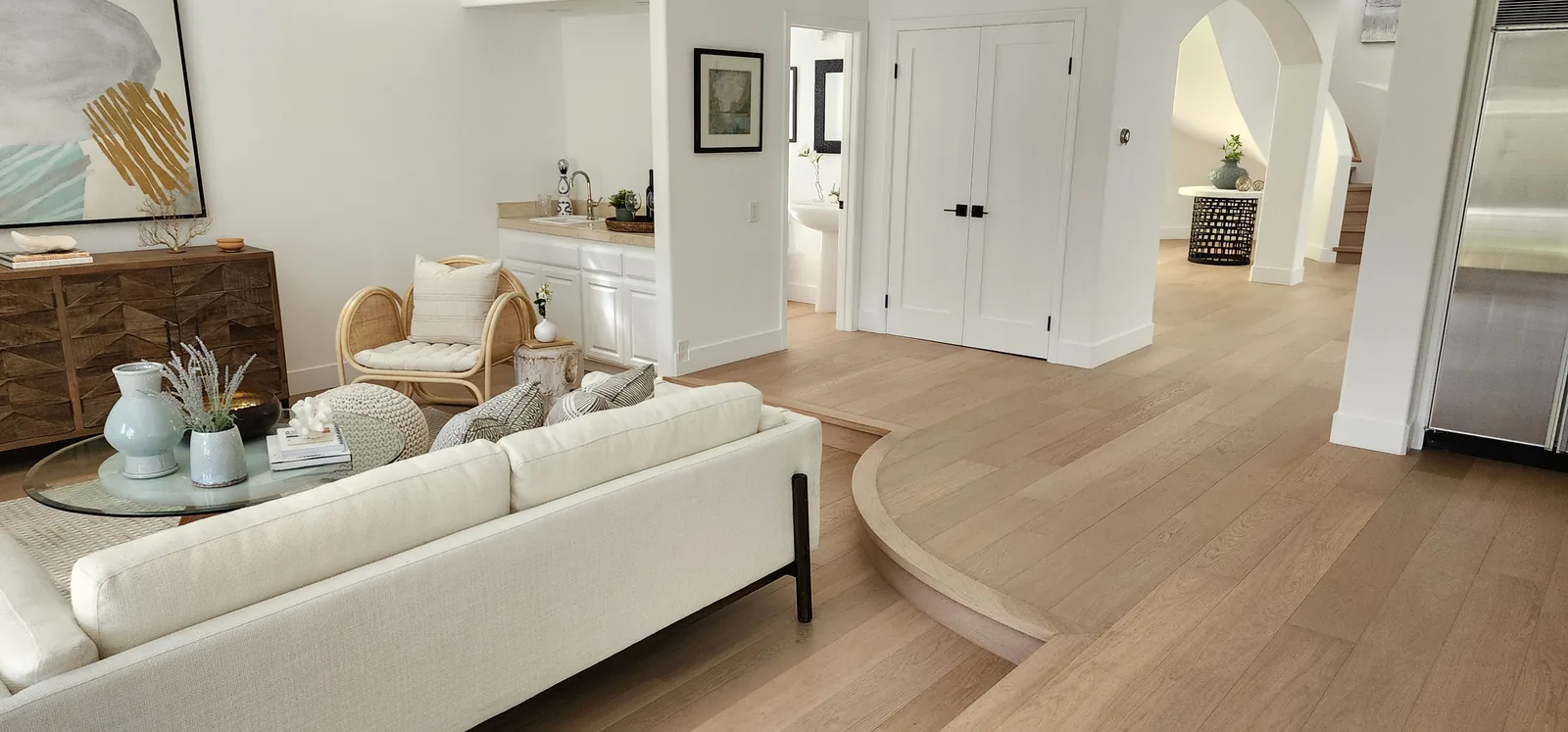 Furnished living room with a curved floor edge in light oak