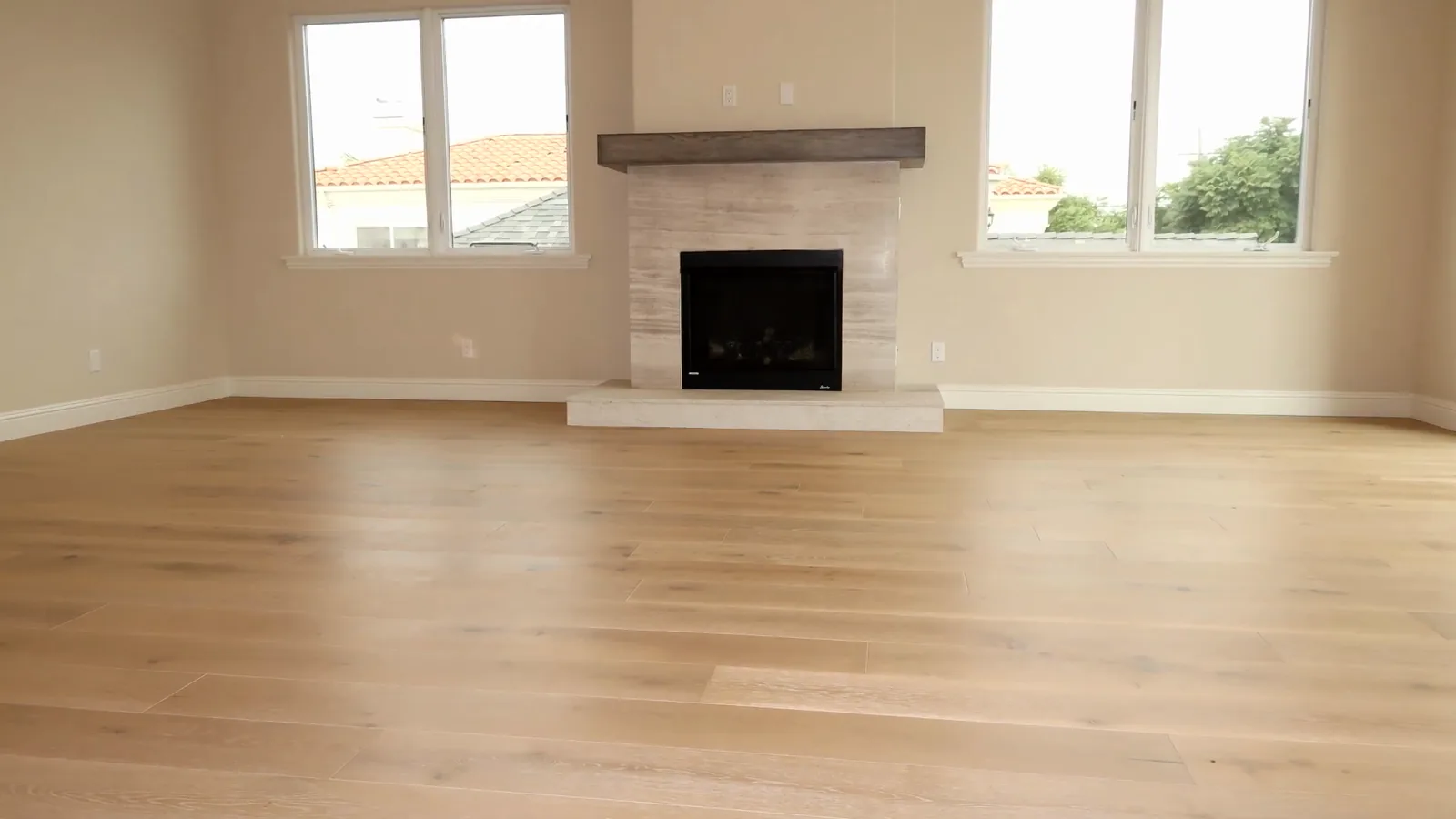 Living room with wide-plank oak floors and a stone fireplace