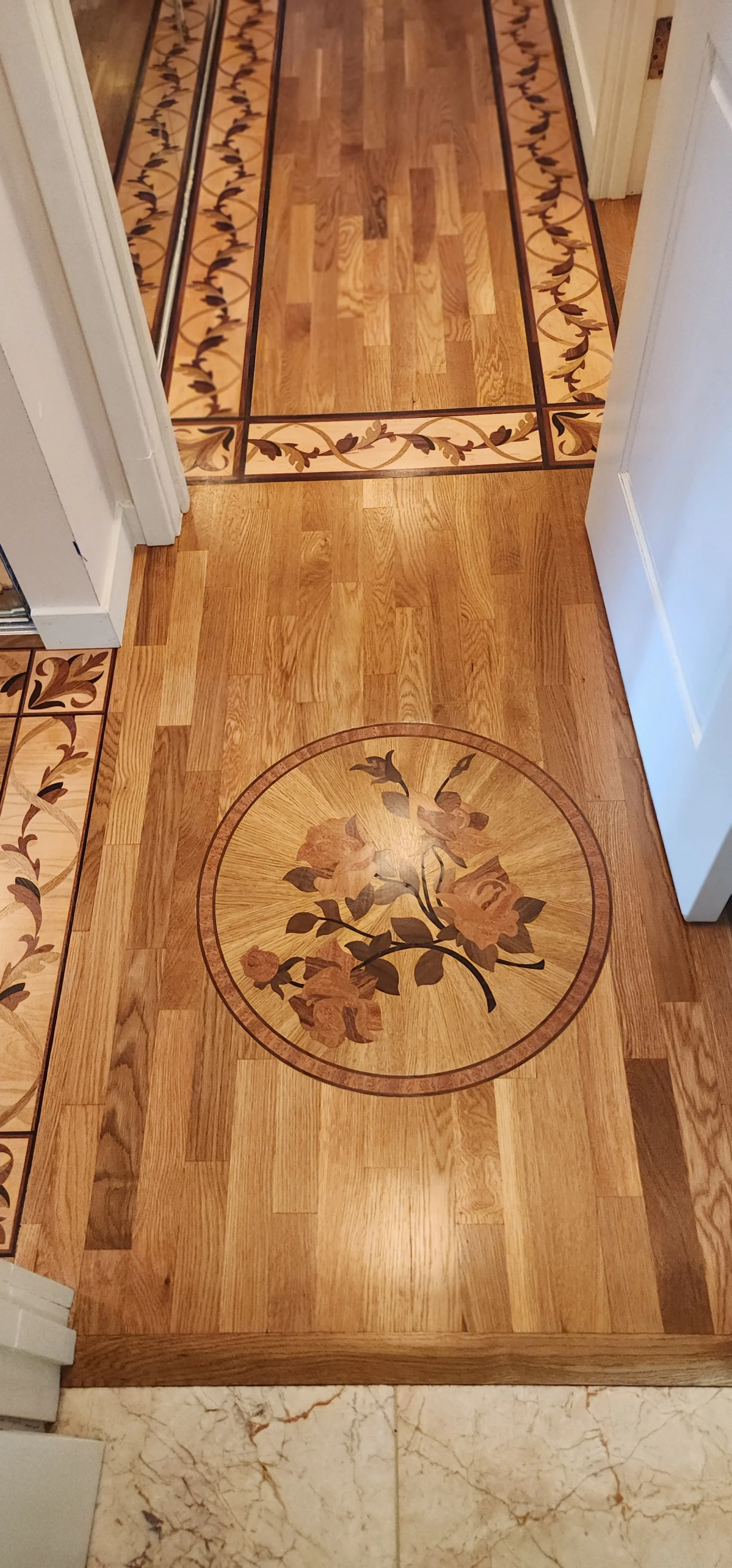 Custom floral rose medallion inlaid into a golden oak floor