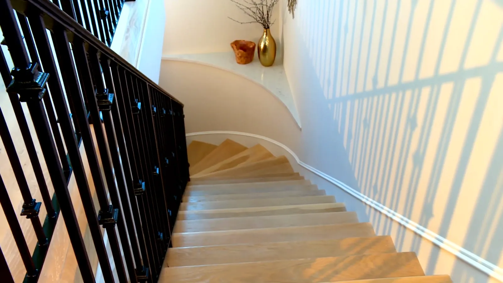 Staircase landing with hardwood and iron railing