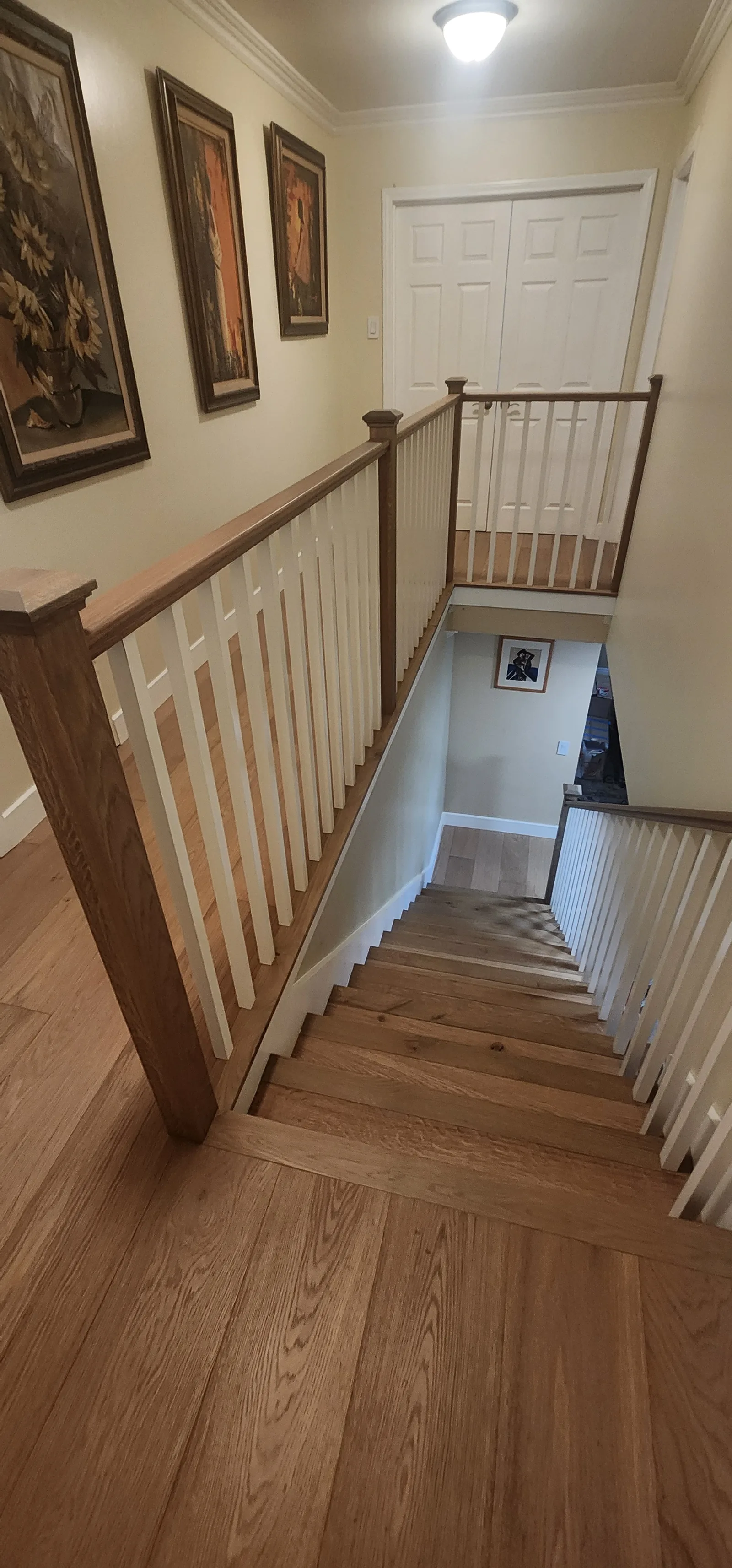 Staircase with white balusters and a wood handrail